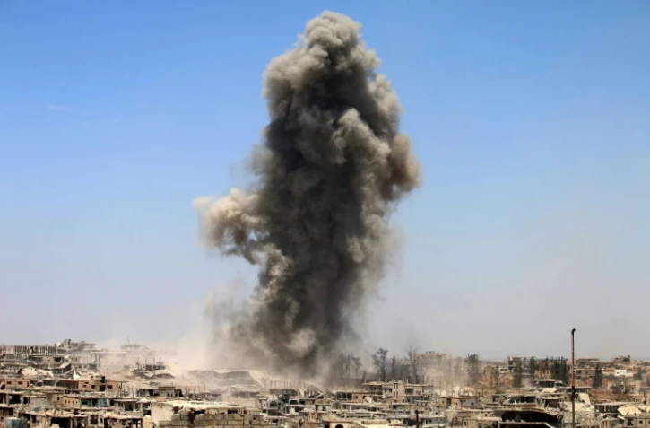 De la fumée s'élève d'un quartier tenu par les rebelles à Daraa (sud de la Syrie) après un frappe aérienne supposée le 22 mai 2017