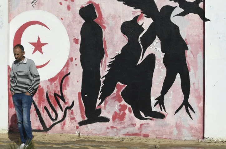 Un Tunisien passe devant une fresque illustrant le désir de liberté, à Sidi Bouzid, le 27 octobre 2020.
