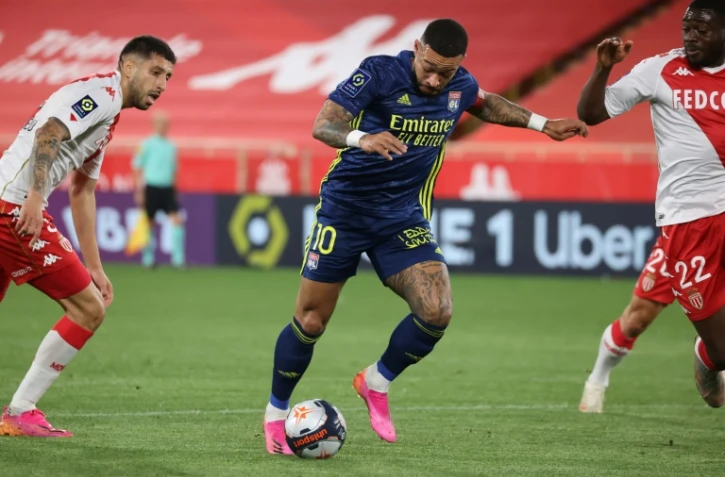 L'attaquant néerlandais Memphis Depay (c) aux prises avec le milieu de Monaco, Youssouf Fofana (d), lors du match de Ligue 1 à Monaco, le 2 mai 2021