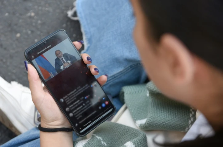 Une femme écoute le discours du Premier ministre arménien Nikol Pachinian dans le centre d'Erevan, le 20 septembre 2023