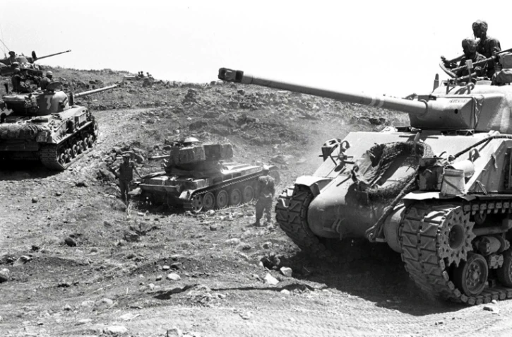 Une photographie fournie par le service de presse de l'armée israélienne, montrant des tanks avançant sur un terrain accidenté du plateau du Golan, le 10 juin 1967