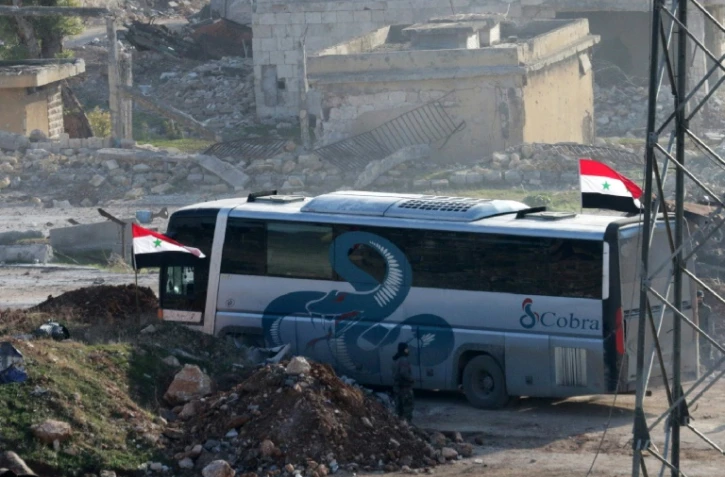 Un bus au passage de Ramoussa, sous contrôle des forces gouvernementales syriennes dans le sud d'Alep, le 18 décembre 2016 dans le cadre d'une opération d'évacuation de civils et de soldats rebelles