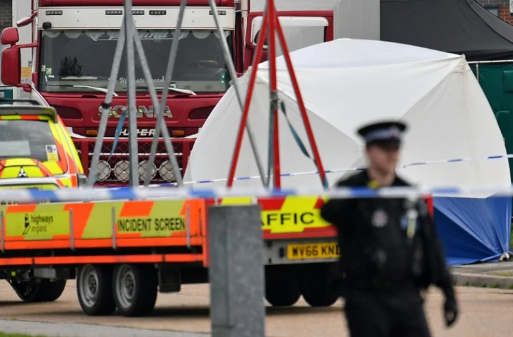 Un camion dans lequel 39 corps ont été découverts est entouré d'un cordon de sécurité par la police après sa découverte sur la zone industrielle de Waterglade à Grays, à environ 35 km de Londres, le 23 octobre 2019