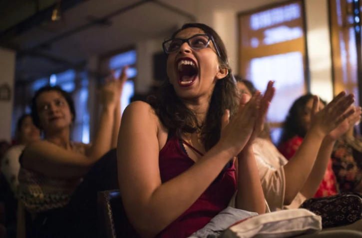 Une spectatrice applaudit lors d'un stand-up réalisé par des femmes devant une audience exclusivement féminine à New Delhi, le 19 août 2018
