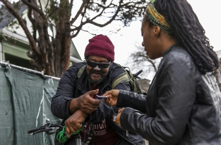 Dominique Walker apportant de l'aide à Mike Wynn, menacé d'expulsion, à Oakland, en Californie, le 28 janiver 2020