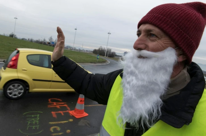 Un "gilet jaune" à un rond-point à Saint-Beauzire (centre), salue les automobilistes, le 15 décembre 2018