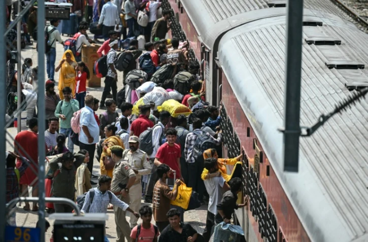 Des habitants tentent de monter dans un train surchargé à la gare de Jammu, le 10 mai 2025 au Cachemire indien