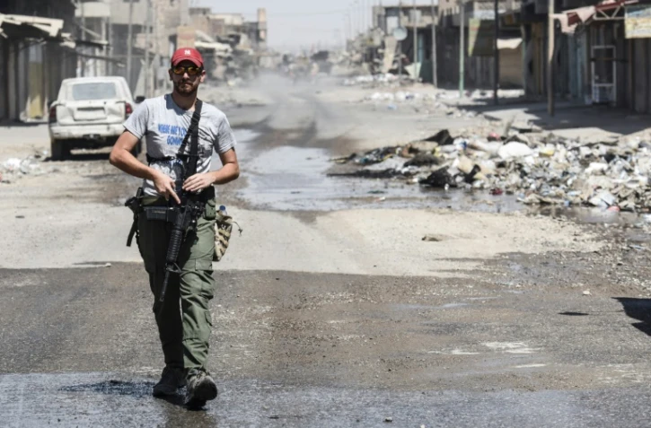 Un membre des forces irakiennes patrouille dans un quartier de Mossoul repris à l'EI, le 23 juin 2017 
