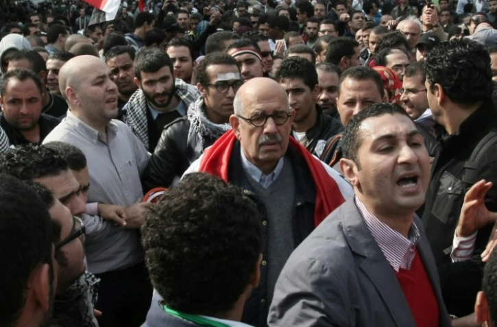 Le prix Nobel de la paix Mohamed ElBaradei (C), portant le drapeau égyptien sur ses épaules, participe à une manifestation sur la place Tahrir au Caire, le 25 novembre 2011
