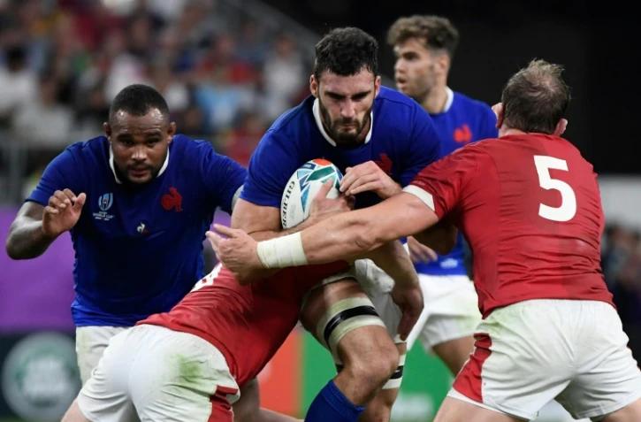 Le 3e ligne du XV de France Charles Ollivon (c) tente de s'échapper avec le ballon face aux Gallois en quarts de finale du Mondial, le 20 octobre 2019 à Oita