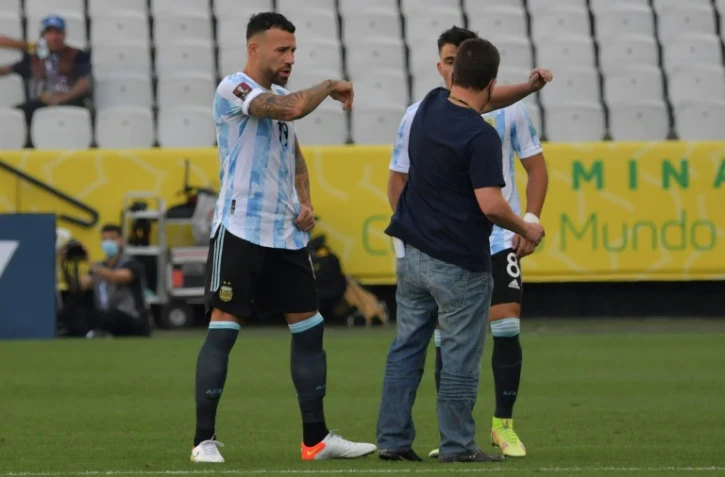 Un employé de l'Agence sanitaire (Anvisa) discute avec des joueurs argentins tout juste après l'interruption du match contre le Brésil à Sao Paulo, le 5 septembre 2021