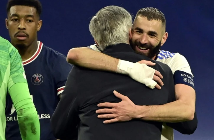 La joie de l'attaquant français du Real Madrid, Karim Benzema, dans les bras de l'entraîneur italien Carlo Ancelotti, après son triplé contre le Paris Saint-Germain, lors du 8e de finale retour de la Ligue des Champions, le 9 mars 2022 au Stade Santiago Bernabeu
