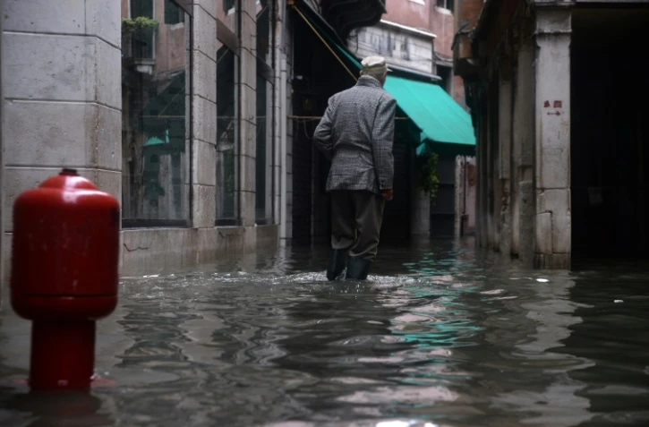 Un homme marche dans une rue inondée de Venise le 17 novembre 2019