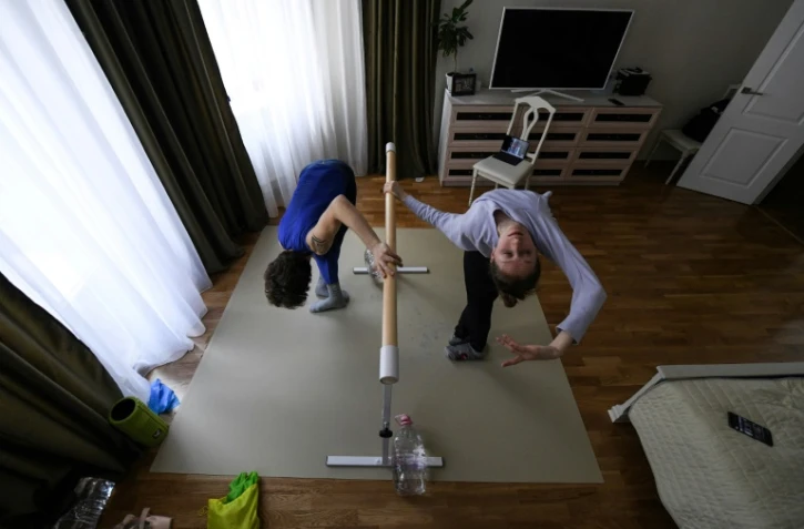 Les danseurs du Bolchoï, Margarita Chraïner et Igor Tsvirko, font leurs exercices dans la chambre de leur appartement, le 29 avril 2020 à Moscou