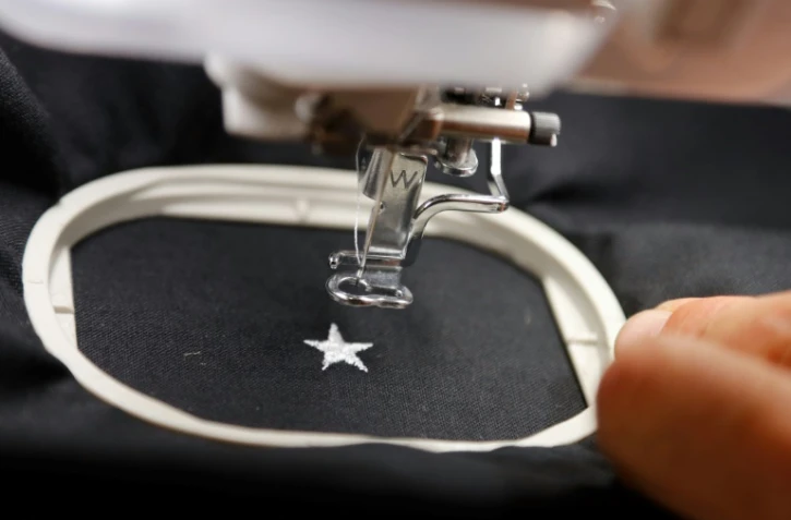 Un brodeur parisien s'applique à coudre une 2e étoile sur le maillot des Bleus, tout frais champions du monde, le 17 juillet 2018 à Paris