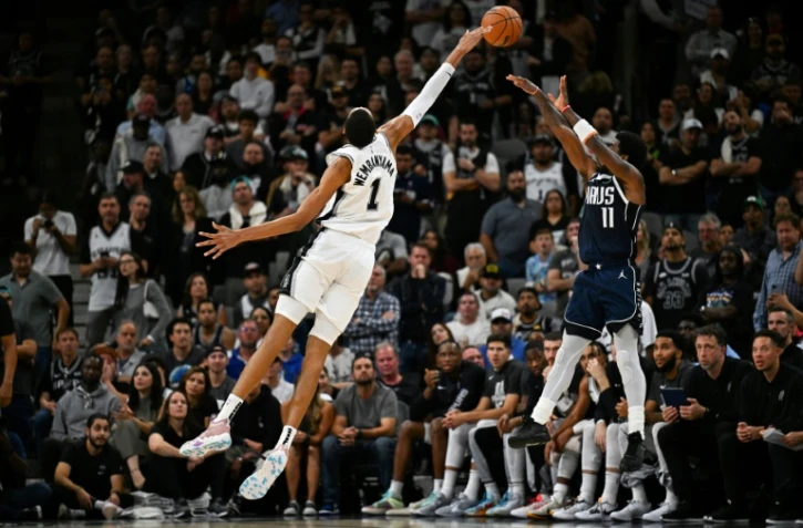 Victor Wembanyama au contre face à Kyrie Irving, un des joueurs majeurs des Dallas Mavericks, le 25 octobre 2023 à San Antonio, pour ses débuts en NBA