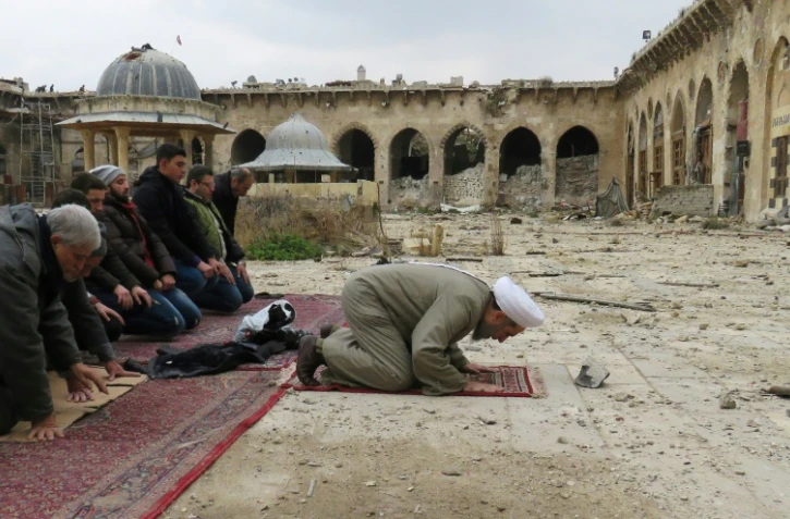 Des Syriens prient dans la mosquée des Omeyades dévastée, le 17 décembre 2016, à Alep.