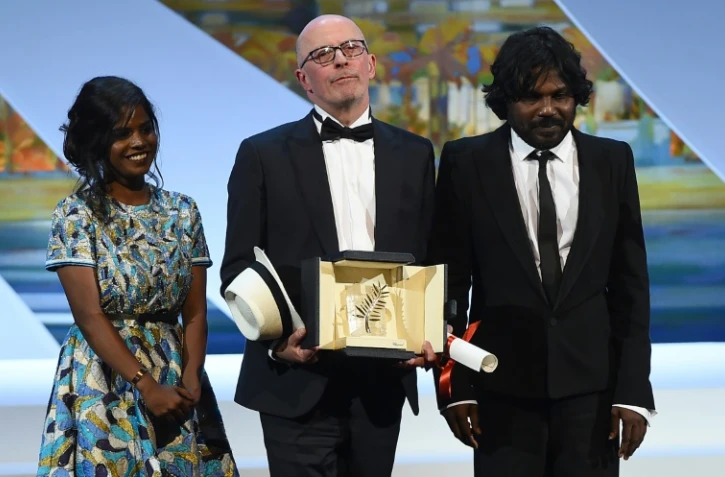 Jacques Audiard et les acteurs sri-lankais Kalieaswari Srinivasan (g) et Jesuthasan Antonythasan récompensés pour le film "Dheepan", le 24 mai 2015 au Festival de Cannes