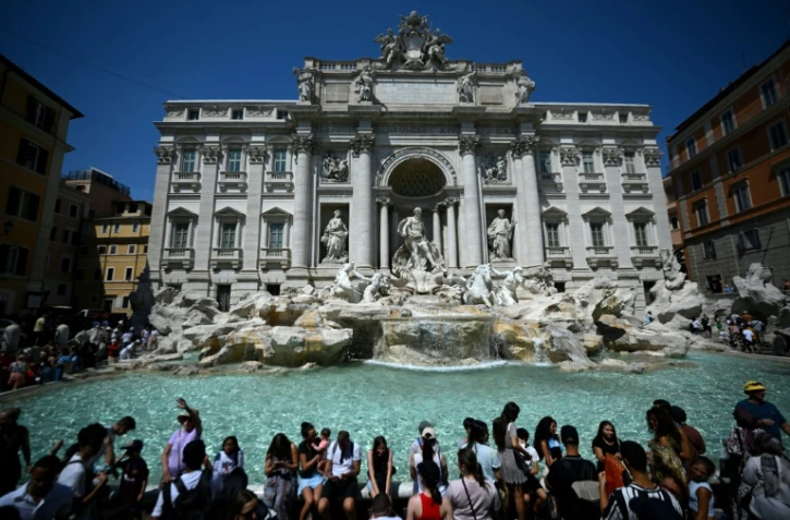 Des touristes se rafraîchissent à la fontaine de Trévi, à Rome, lors d'une vague de chaleur, le 21 août 2023