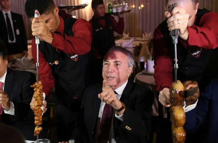 Le président brésilien Michel Temer lors d'un barbecue auquel des ambassadeurs étrangers étaient invités après une réunion  d'urgence sur le démantèlement d'un réseau de commercialisation de viande avariée au Brésil, le 19 mars 2017 à Brasilia