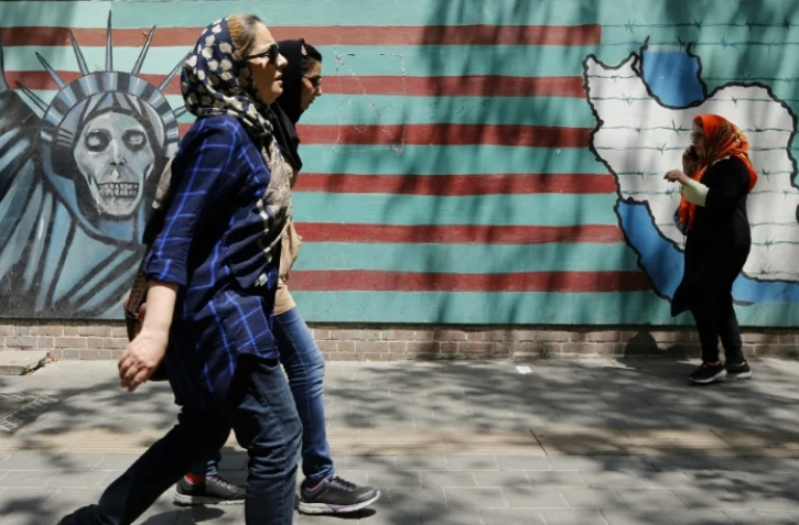 Des Iraniennes passent devant la façade de l'ancienne ambassade des Etats-Unis à Téhéran le 7 août 2018.