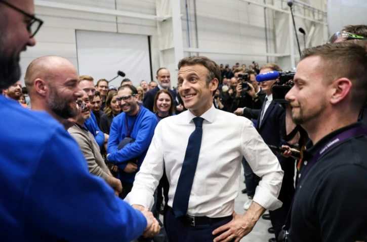 Le président-candidat à sa réélection Emmanuel Macron serre la main d'un ouvrier à l'usine Siemens Gamesa au Havre, nord-ouest, le 14 avril 2022
