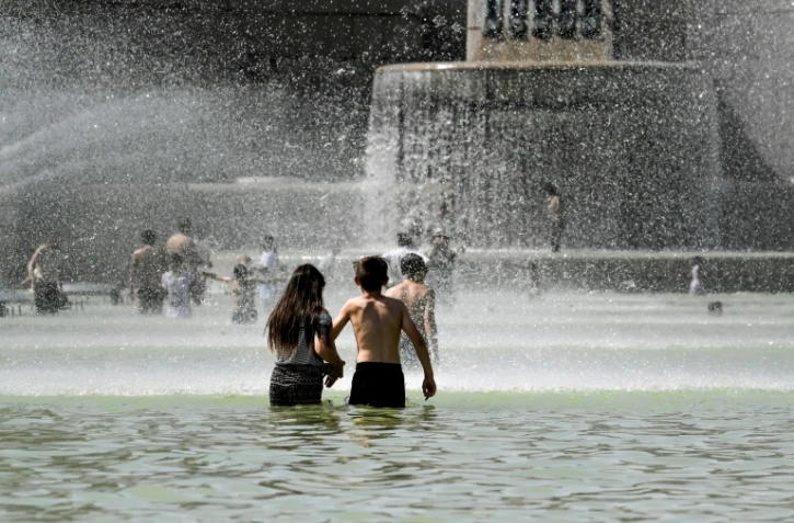 Des enfants se rafraîchissent dans les bassins de la fontaine du Trocadéro lors d'un épisode de fortes chaleurs, le 22 juillet 2019 à Paris