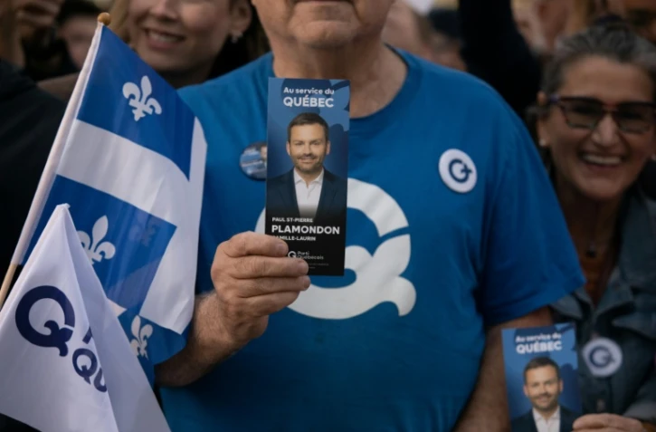 Un sympathisant tient un tract à l'effigie du chef du Parti québécois (PQ), Paul St-Pierre Plamondon, devant la Maison de Radio-Canada à Montréal, dans la province de Québec au Canada, le 23 septembre 2026