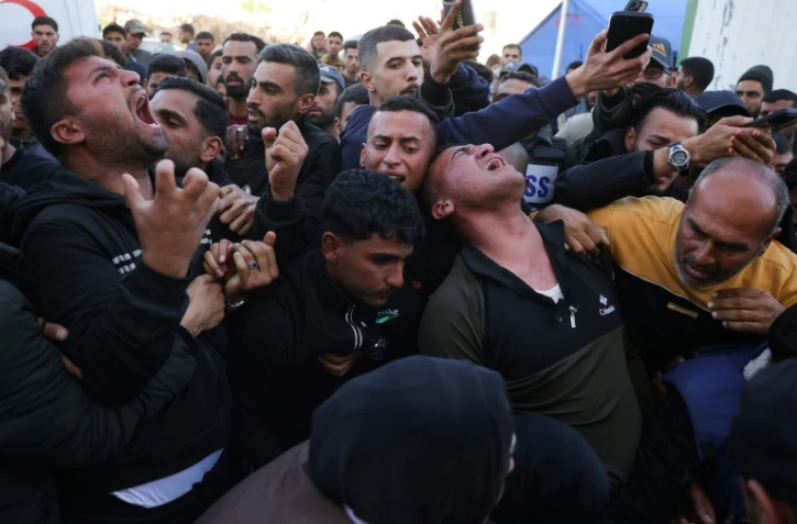 Des proches pleurent le journaliste palestinien Hossam Shabat, qui collaborait avec Al Jazeera, lors de ses funérailles à l'hôpital indonésien de Beit Lahia, dans le nord de la bande de Gaza, le 24 mars 2025