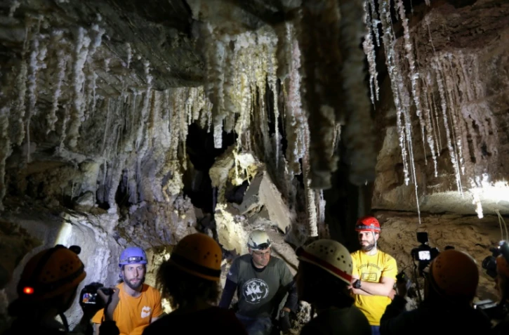 Boaz Langford (D), Yoav Negev (2e G) et Efraim Cohen (G), des spéléologues israéliens, s'expriment devant la presse dans la grotte de sel Malham qui s'étend du  Mont Sedom jusqu'au sud de la mer Morte, en Israël le 27 mars 2019