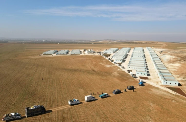 Vue aérienne d'un convoi de déplacés syriens arrivant au complexe résidentiel, construit près de la ville d'al-Bab, le 9 février 2022 en Syrie 