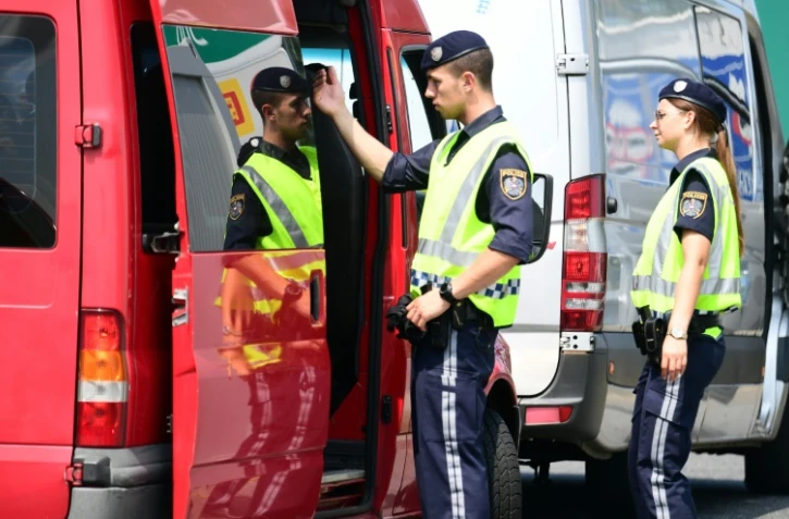 Des policiers autrichiens inspectent un véhicule à la frontière austro-hongroise à Nickeldsdorf, le 12 juillet 2016