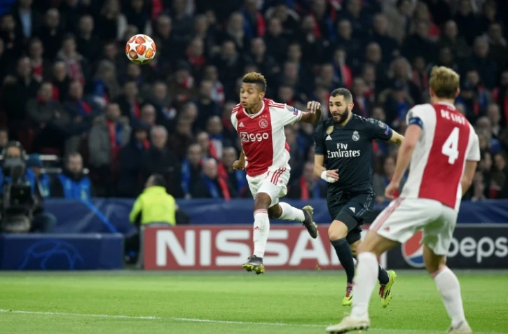 Le Français du Real Madrid Karim Benzema (c) entre deux joueurs de l'Ajax dont David Neres (g), en 8e de finale aller de la C1, le 13 février 2019 à Amsterdam 