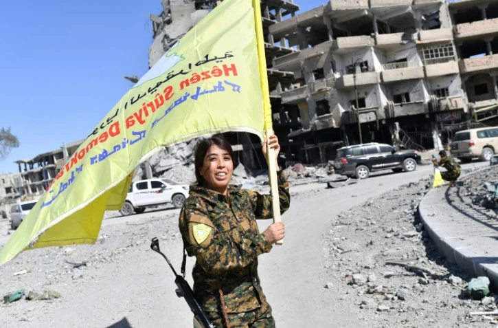 Rojda Felat, une commandante des Forces démocratiques syriennes, brandit le drapeau de son groupe à Raqa le 17 octobre 2017