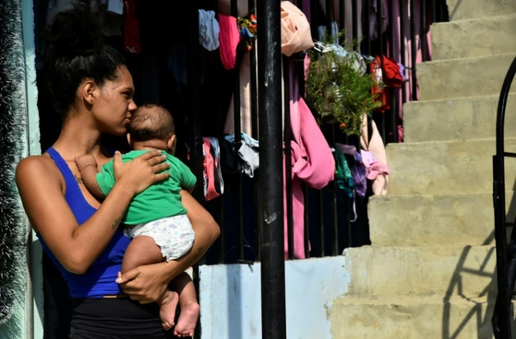 Une femme porte un bébé, à La Fortaleza près de Cucuta, en Colombie, le 9 janvier 2026