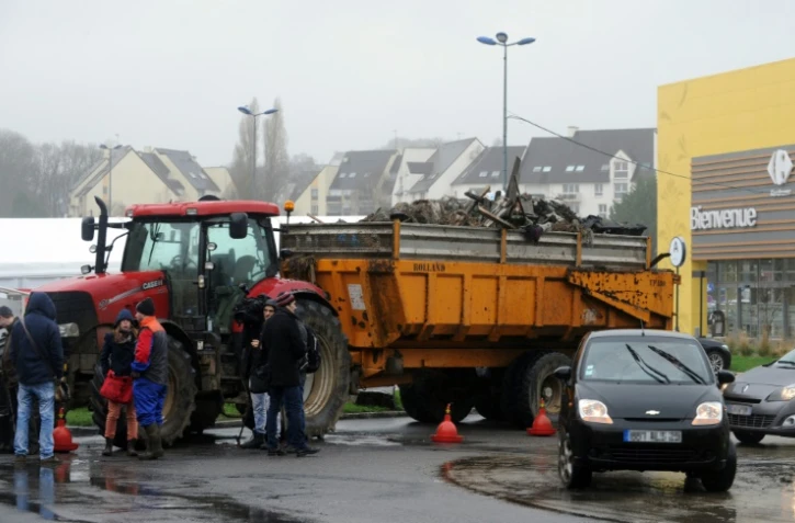 Des agriculteurs français bloquent l'accès à un hypermarché avec leurs tracteurs et leurs remorques chargées de déchets à Quimper, le 2 février 2016