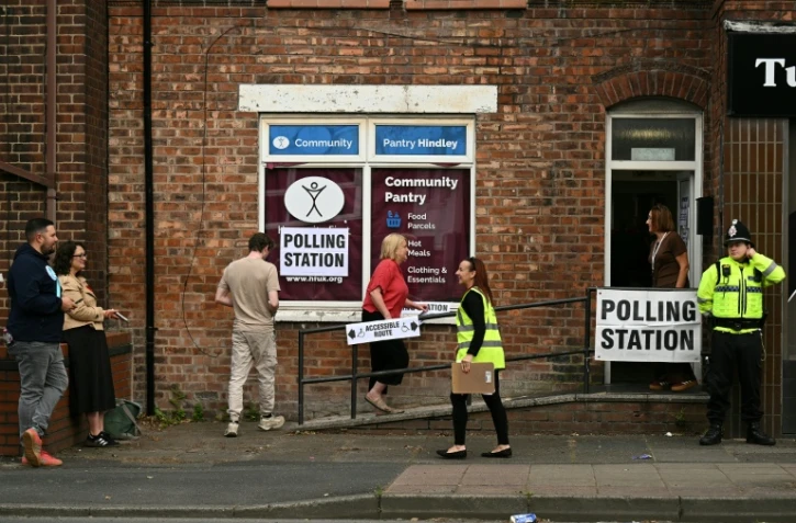 Des électeurs arrivent pour voter à l'élection partielle de Makerfield, dans le nord-ouest de l'Angleterre, dans un bureau de vote installé dans un centre communautaire à Hindley, le 18 juin 2026