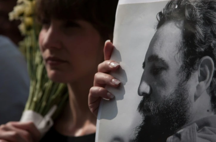 Une femme tient un portrait de Fidel Castro lors d'un rassemblement devant l'ambassade de Cuba à Mexico, le 27 novembre 2016