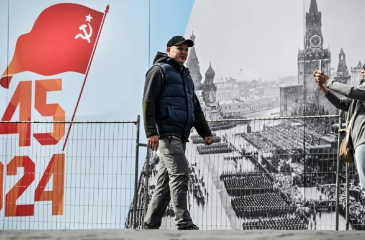 Des personnes flannent sur la place Rouge décorée à l'occasion du 79e anniversaire de la victoire de l'Union soviétique sur l'Allemagne nazie, le 23 avril 2024 à Moscou