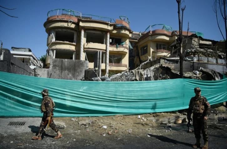 Des membres des forces de sécurité afghanes sur les lieux d'une attaque revendiquée par les talibans contre un immeuble abritant l'ONG américaine Counterpart, le 9 mai 2019 à Kaboul