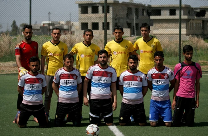 Des joueurs irakiens portent les maillots des équipes de football du Bayern Munich (en bas) et du Borussia de Dortmund (en haut), le 7 avril 2017 à Mossoul