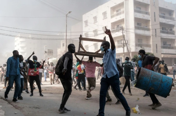 Des manifestants entonnent des slogans lors d'affrontements avec la police, le 9 février 2024 à Dakar