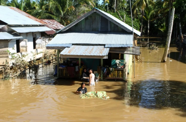 Des habitants de Bengkulu en Indonésie dans leur maison inondée par les suites des pluies torrentielles qui ont touché l'archipel, le 29 avril 2019