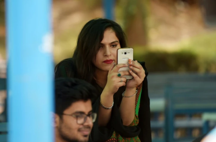 Une étudiante utilise un smartphone sur le campus d'Islamabad le 12 juillet 2018