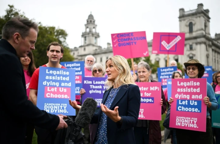 La députée travailliste Kim Leadbeater s'exprime devant la presse, avec des militants de l'association Dignity in Dying (Dignité face à la mort) rassemblés devant le Parlement