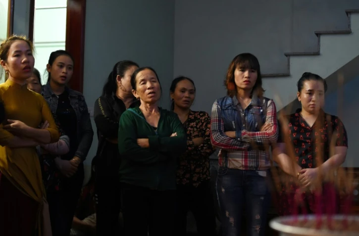 Des proches de Bui Thi Nhung, qui pourrait être une des 39 migrants retrouvés morts dans un camion en Grande-Bretagne, prient devant un autel improvisé, dans sa maison du centre du Vietnam, le 26 octobre 2019