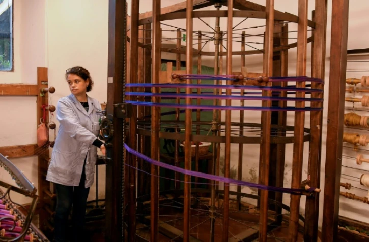 Une femme trie des fils de soie sur un ourdissoir d'un modèle conçu par Léonard de Vinci, le 29 octobre 2018 à Florence, en Italie