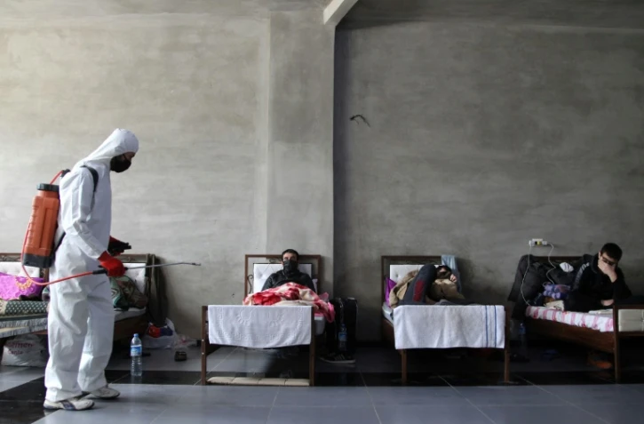 Désinfection dans une chambre à Jisr al-Shughur, dans la province d'Idleb en Syrie, qui accueille des Syriens placés en quarantaine après leur retour de Turquie, le 27 avril 2020