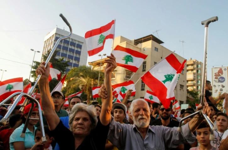 Munis de drapeaux, des Libanais manifestent contre la classe politique à Saïda, dans le sud du Liban le 21 octobre 2019