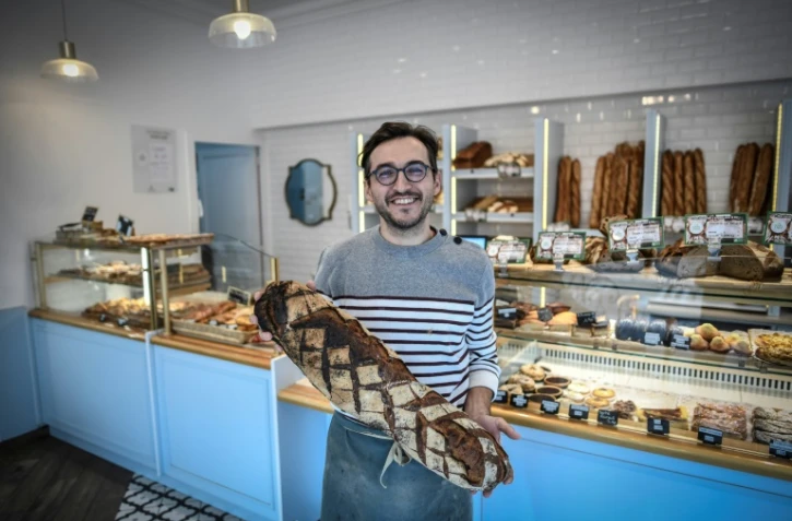 Un boulanger pose dans sa boutique à Paris le 27 novembre 2020
